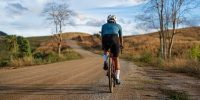 Un cycliste sur une route de campagne par beau temps.